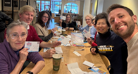 Michael and volunteers writing postcards to voters
